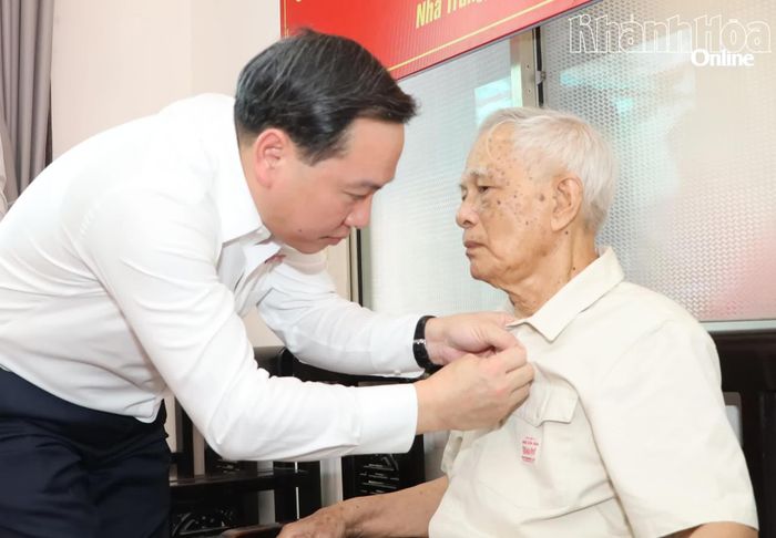 Phó Bí thư Thường trực Tỉnh ủy Hồ Xuân Trường gắn Huy hiệu 60 năm tuổi Đảng lên ngực áo đồng chí Nguyễn Thiết Hùng.
