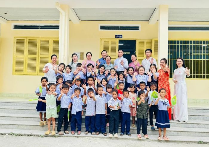 Lãnh đạo xã Khánh Sơn, đại diện Chương trình "Cặp lá yêu thương" và nhà tài trợ chụp ảnh lưu niệm với giáo viên, học sinh của điểm trường Cô Lắk.