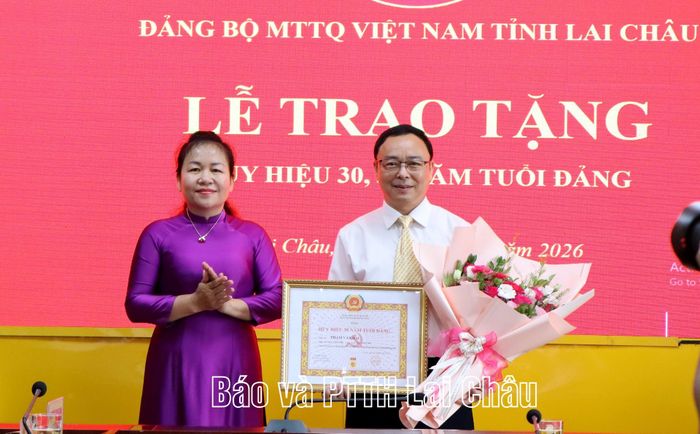 Đồng chí Khoảng Thị Thanh Nga - Phó Bí thư Đảng ủy Các cơ quan Đảng tỉnh trao Huy hiệu Đảng và chúc mừng đảng viên Phạm Văn Hải.