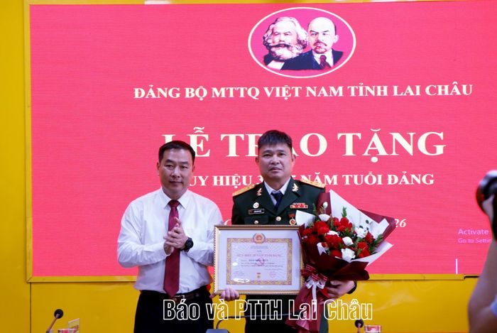 Đồng chí Tống Thanh Bình - Bí thư Đảng ủy, Phó Chủ tịch Thường trực Ủy ban MTTQ Việt Nam tỉnh trao Huy hiệu Đảng và chúc mừng đảng viên Đàm Minh Hiển.