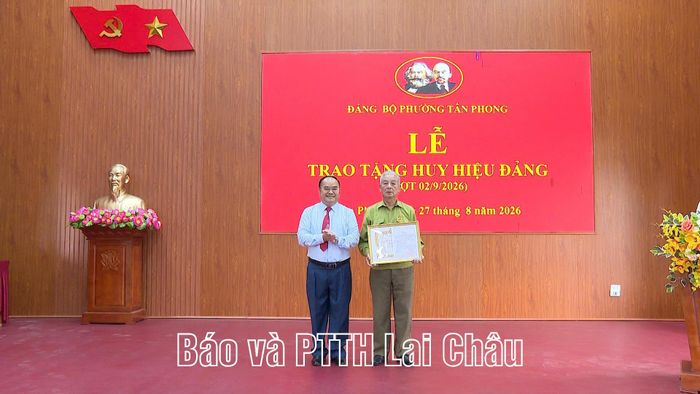Bí thư Đảng ủy phường Tân Phong Mùa A Trừ trao Huy hiệu 55 năm tuổi Đảng cho đảng viên Vũ Hồng Khanh.