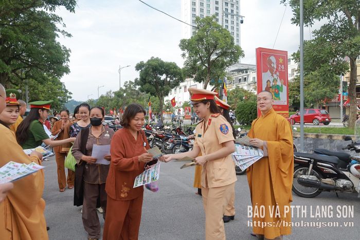 Lực lượng chức năng phát tờ rơi tuyên truyền về an toàn giao thông đến người dân dự Đại lễ Vu Lan năm 2026