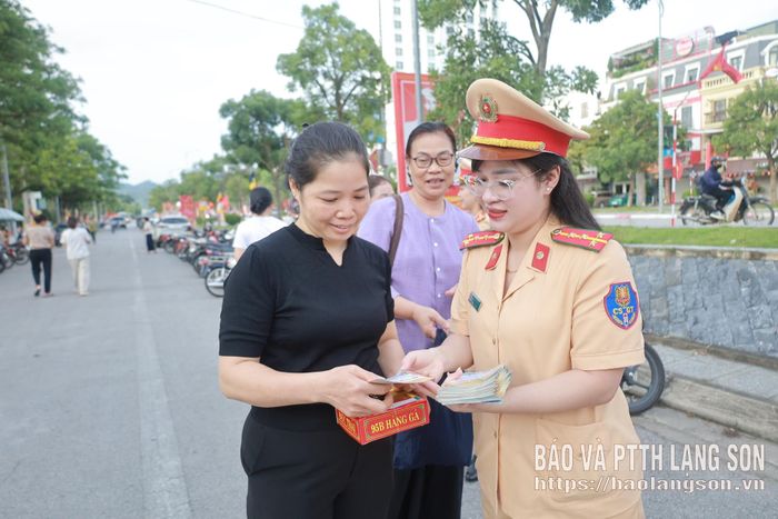 Cán bộ Phòng CSGT phát tờ rơi tuyên truyền về an toàn giao thông đến người dân dự Đại lễ Vu Lan năm 2026