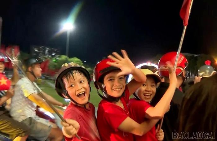 Nụ cười rạng rỡ của các em nhỏ trong đêm mừng chiến thắng của đội tuyển Việt Nam.