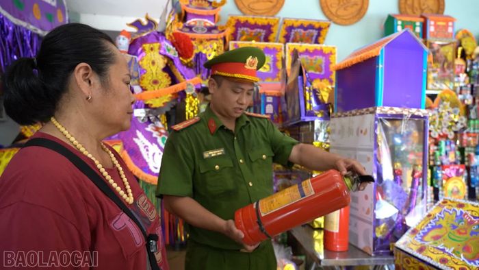 Lực lượng chức năng kiểm tra hạn sử dụng và áp suất bình chữa cháy tại các hộ kinh doanh quanh đền.