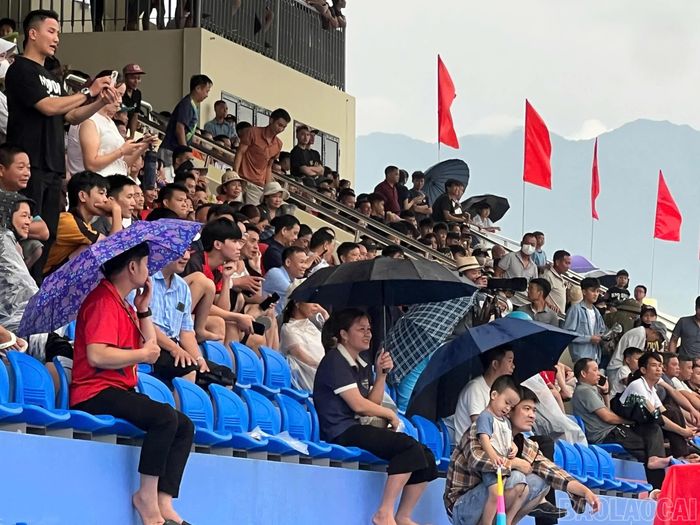 Khán giả đội mưa cổ vũ các đội bóng.