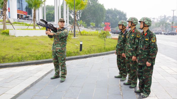 Chỉ huy tổ chế áp UAV hướng dẫn sử dụng súng chế áp phương tiện bay không người lái. Ảnh: Mai Linh