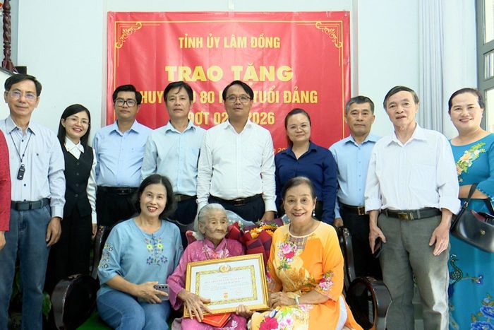Đồng chí Đặng Hồng Sỹ cùng các đại biểu và gia đình chụp ảnh lưu niệm với đảng viên Lâm Thị Xuân Mai sau lễ trao tặng Huy hiệu 80 năm tuổi Đảng