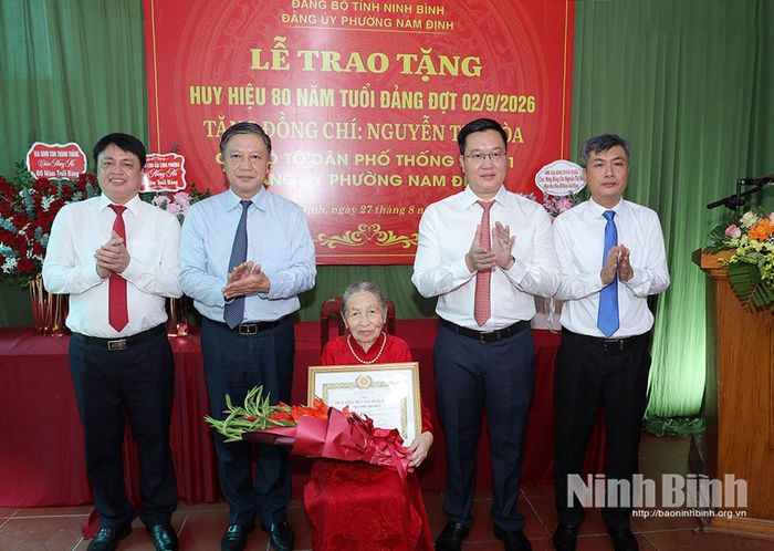 Đồng chí Trần Đăng Quỳnh, Ủy viên dự khuyết Trung ương Đảng, Phó Bí thư Thường trực Tỉnh ủy và các đại biểu chúc mừng đồng chí Nguyễn Thị Hòa, đảng viên Chi bộ Tổ dân phố Thống Nhất 1, Đảng bộ phường Nam Định.