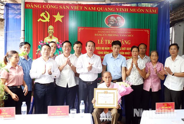 Các đại biểu và gia đình chụp ảnh lưu niệm cùng đảng viên Đinh Văn Nhật, Chi bộ Tổ dân phố Khuyến Công, Đảng bộ phường Tam Chúc.