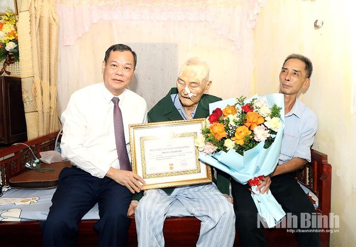 Đồng chí Lê Quốc Chỉnh, Phó Bí thư Tỉnh ủy, Chủ tịch HĐND tỉnh trao tặng Huy hiệu 80 năm tuổi Đảng cho đồng chí Trần Văn Khánh, đảng viên Chi bộ thôn Cát Trung, Đảng bộ xã Minh Thái.
