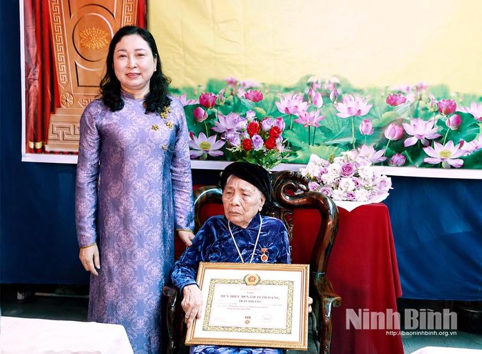 Đồng chí Đinh Thị Lụa, Phó Bí thư Tỉnh ủy, Chủ tịch Ủy ban MTTQ Việt Nam tỉnh trao tặng Huy hiệu 80 năm tuổi Đảng cho đồng chí Trần Thị Vui, Chi bộ thôn Nam Cao, Đảng bộ xã Nam Lý.