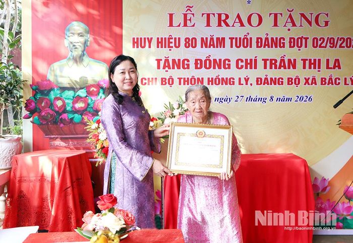 Đồng chí Đinh Thị Lụa, Phó Bí thư Tỉnh ủy, Chủ tịch Ủy ban MTTQ Việt Nam tỉnh trao tặng Huy hiệu 80 năm tuổi Đảng cho đồng chí Trần Thị La, Chi bộ thôn Hồng Lý, Đảng bộ xã Bắc Lý.