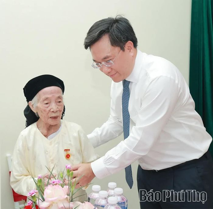 Chủ tịch UBND tỉnh Trần Duy Đông trao Huy hiệu Đảng và thăm hỏi sức khỏe đảng viên lão thành Bùi Thị Kén.