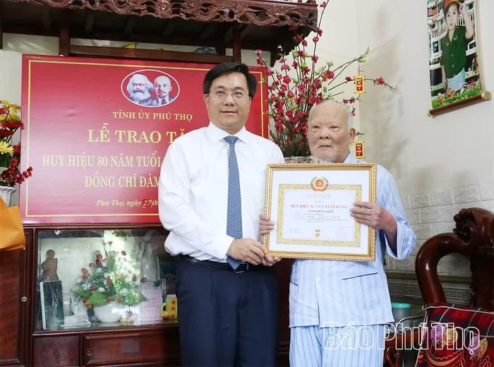 Chủ tịch UBND tỉnh Trần Duy Đông trao Huy hiệu 80 năm tuổi Đảng tặng đảng viên lão thành Đàm Hồng Khê.