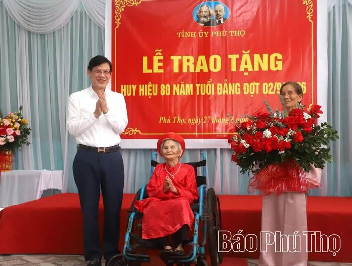 Lãnh đạo xã Phú Mỹ tặng hoa chúc mừng đồng chí Hoàng Thị Dinh.