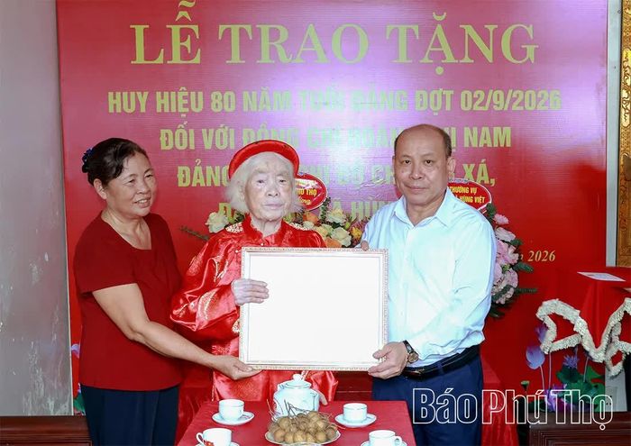 Đồng chí Phó Bí thư Tỉnh ủy, Chủ tịch HĐND tỉnh Bùi Đức Hinh trao Huy hiệu 80 năm tuổi Đảng tặng đảng viên Hoàng Thị Nam.