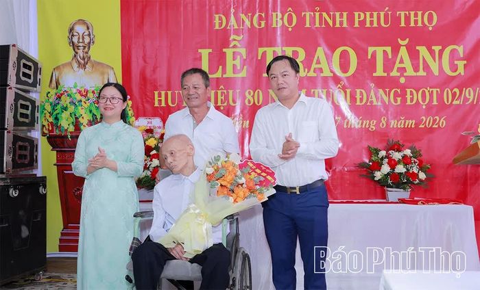 Lãnh đạo xã Hiền Lương tặng hoa chúc mừng đảng viên Nguyễn Văn Phụ.