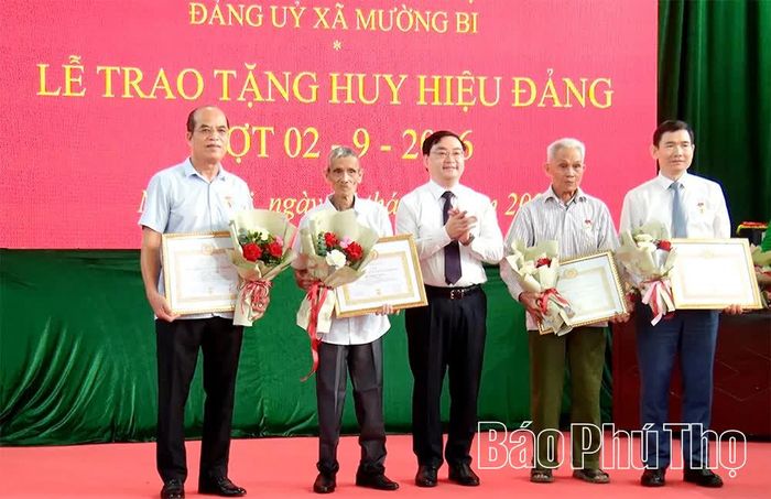 Đồng chí Quách Thế Ngọc - Ủy viên Ban Thường vụ Tỉnh ủy, Trưởng Ban Nội chính Tỉnh ủy trao Huy hiệu Đảng tặng các đảng viên.