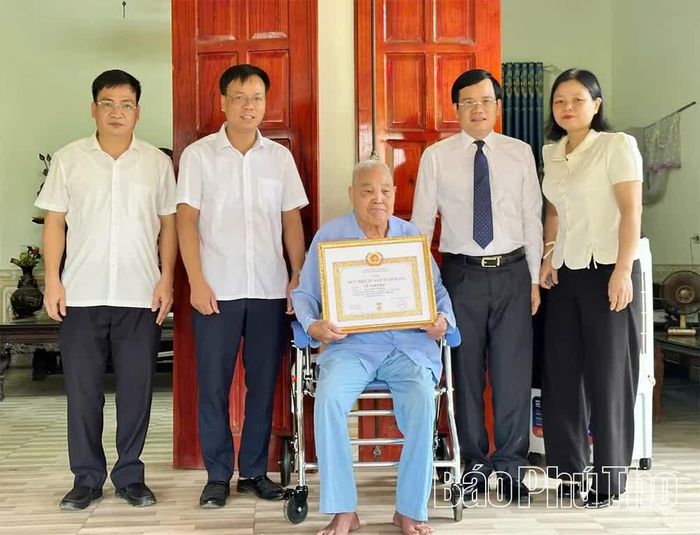 Lãnh đạo Sở Tư pháp và xã Vĩnh Chân trao tặng Huy hiệu 65 năm tuổi Đảng cho đảng viên Lê Thế Khải.