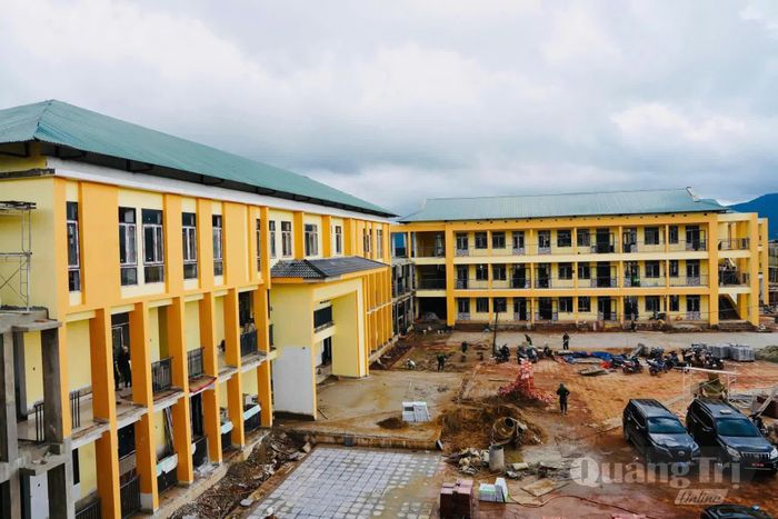 Khối phòng học cao tầng thuộc dự án Trường nội trú tiểu học và THCS Hướng Phùng cùng khuôn viên sân trường đang được san gạt, lát gạch - Ảnh: Mỹ Nhị