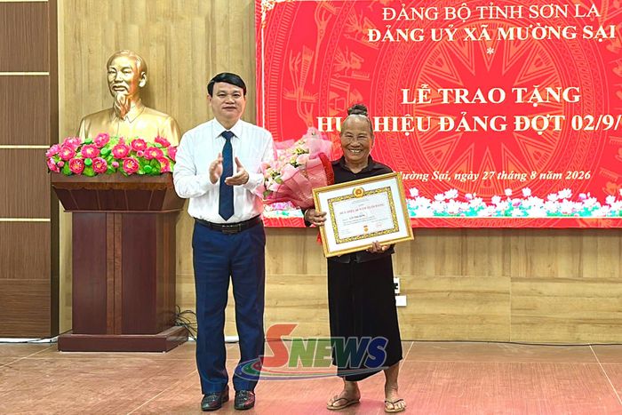 Đồng chí Phó Chủ tịch UBND tỉnh trao huy hiệu 60 năm tuổi Đảng cho đảng viên Lò Thị Lón, Chi bộ bản Coi, xã Mường Sại