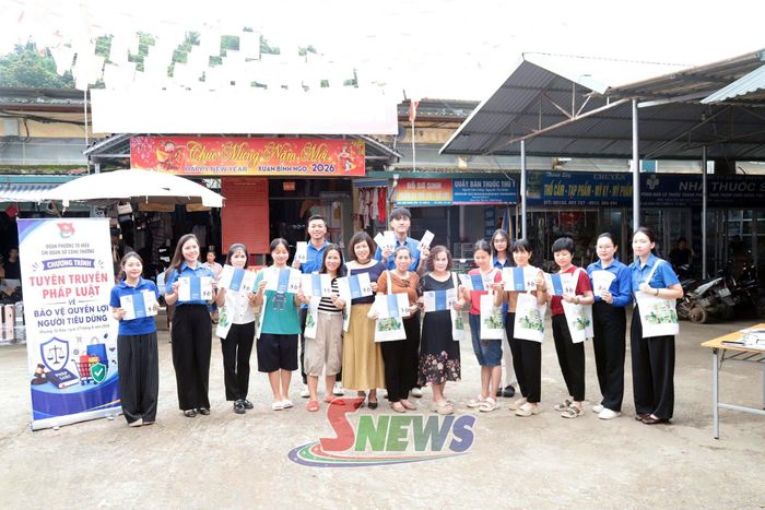 Các đoàn viên tuyên truyền và tặng túi vải đi chợ cho các tiểu thương và người tiêu dùng tại Chợ Trung tâm, phường Tô Hiệu.
