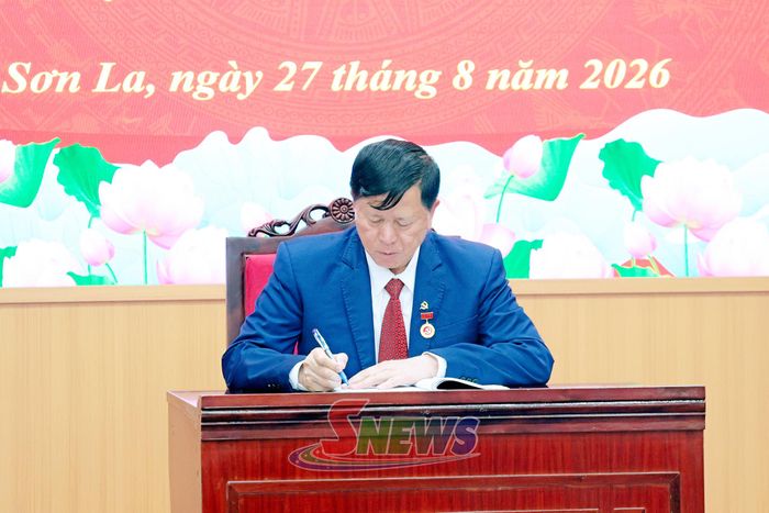 Đồng chí Cầm Ngọc Minh, nguyên Phó Bí thư Tỉnh ủy, nguyên Chủ tịch UBND tỉnh, ký sổ tặng Huy hiệu Đảng.