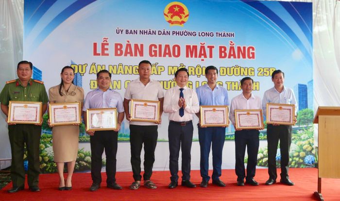 Phường Long Thành trao giấy khen cho người dân bàn giao mặt bằng sớm (trái) và các lực lượng, cá nhân làm tốt công tác GPMB.