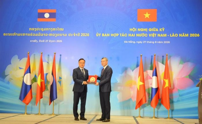 Bộ trưởng Bộ Tài chính Ngô Văn Tuấn (bên phải) và Phó Thủ tướng, kiêm Bộ trưởng Bộ Tài chính Lào trao quà lưu niệm. Ảnh: Hà Minh