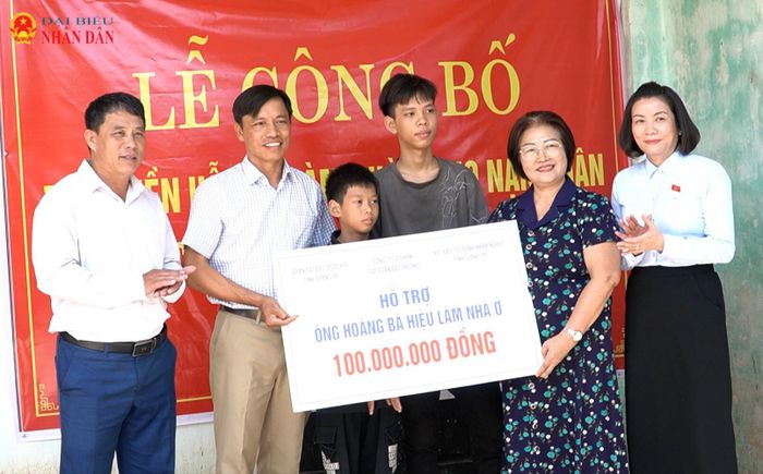 Phó Trưởng đoàn chuyên trách Đoàn ĐBQH Quảng Trị Nguyễn Minh Tâm (thứ hai từ phải sang) trao kinh phí hỗ trợ xây dựng nhà tình nghĩa cho gia đình ông Hoàng Bá Hiểu, nạn nhân chất độc da cam, trú tại thôn Thượng Hải, xã Sen Ngư