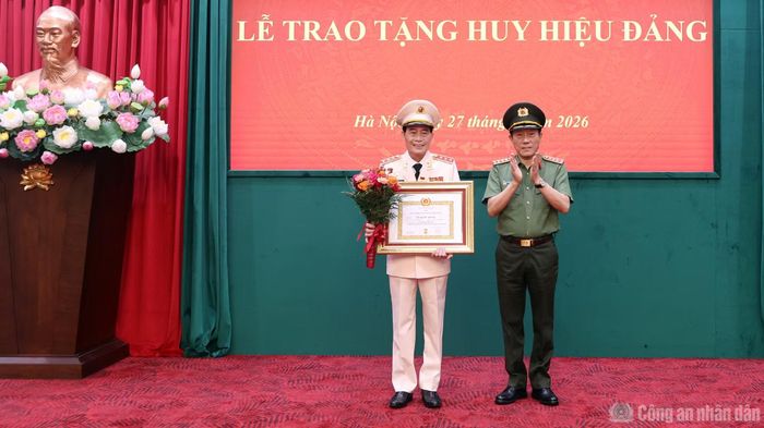Bộ trưởng Lương Tam Quang trao Giấy chứng nhận, gắn Huy hiệu 35 năm tuổi Đảng và tặng hoa chúc mừng Thứ trưởng Lê Quốc Hùng