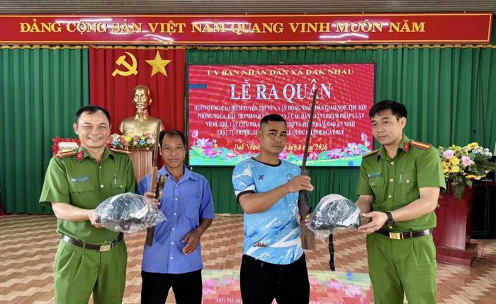 Công an địa phương tiếp nhận vũ khí và tặng quà cho người dân tự nguyện giao nộp.
