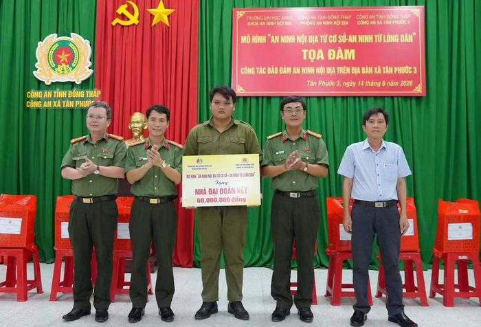 Đại tá Nguyễn Minh Tân, Phó Giám đốc Công an tỉnh Đồng Tháp trao tiền xây nhà đại đoàn kết tặng thành viên lực lượng tham gia đảm bảo ANTT ở cơ sở.