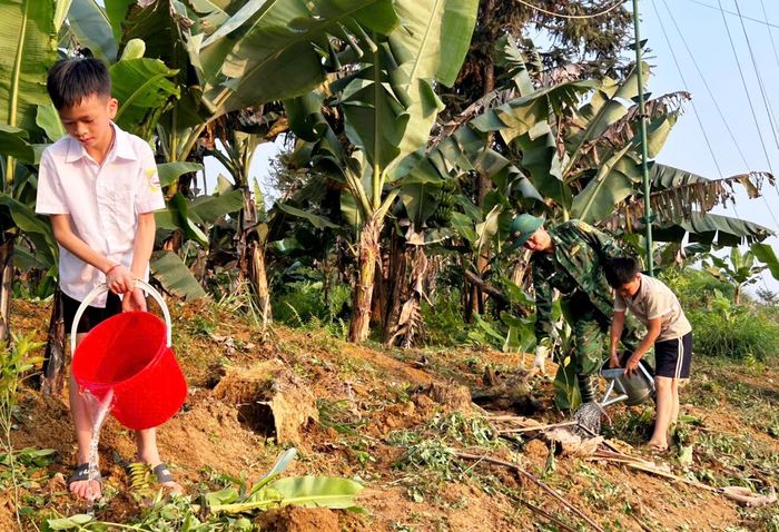 Hướng dẫn con nuôi Đồn Biên phòng Bát Xát trồng cây, tăng gia sản xuất tại đơn vị. Ảnh: Trần Hà