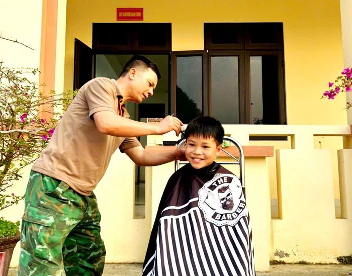 Cắt tóc cho con nuôi Đồn Biên phòng. Ảnh: Trần Hà