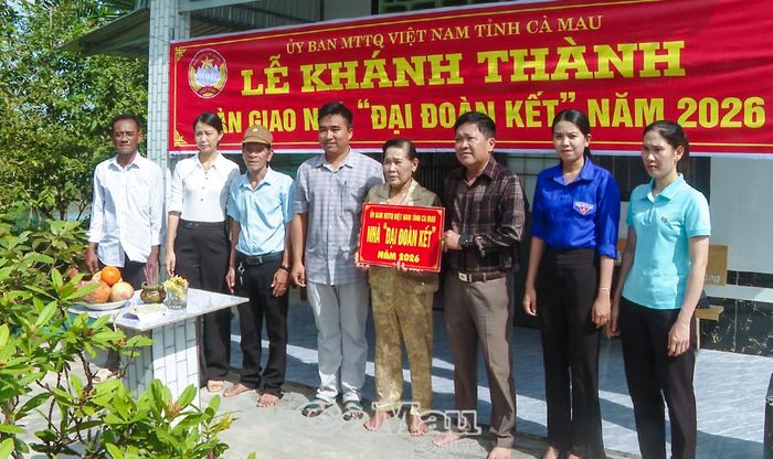 Đồng chí Nguyễn Văn Vàng, Phó Bí thư Thường trực Đảng uỷ phường Láng Tròn (thứ 3 từ phải sang), trao bảng tượng trưng nhà Đại đoàn kết cho bà Đặng Thị Tím.