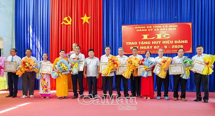 Đồng chí Nguyễn Phương Đông, Bí thư Đảng uỷ, Chủ tịch HĐND xã Đất Mới (thứ 6 từ trái sang), trao Huy hiệu 35 năm tuổi Đảng cho các đảng viên.