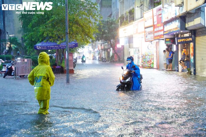 Tại tuyến phố Dịch Vọng, lực lượng chức năng luôn có mặt ở những điểm ngập sâu để xử lý thoát nước và hướng dẫn người dân không đi vào các điểm ngập.