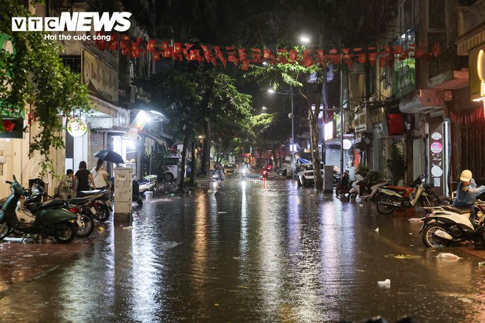 Tại phố Hòe Nhai, nước rút nhanh, các phương tiện bắt đầu đi lại bình thường trở lại. Người dân cũng tranh thủ dọn dẹp sau mưa.