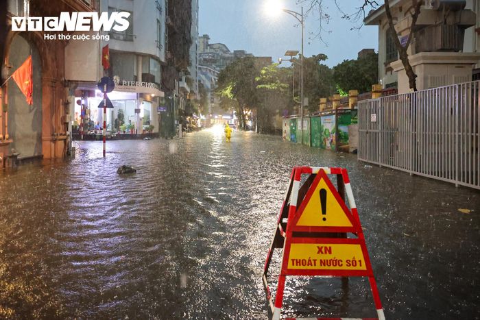 Tại phố Nguyễn Trường Tộ, công nhân Xí nghiệp Thoát nước có mặt, đặt biển cảnh báo để hướng dẫn, nhắc nhở người dân khi đi qua khu vực.