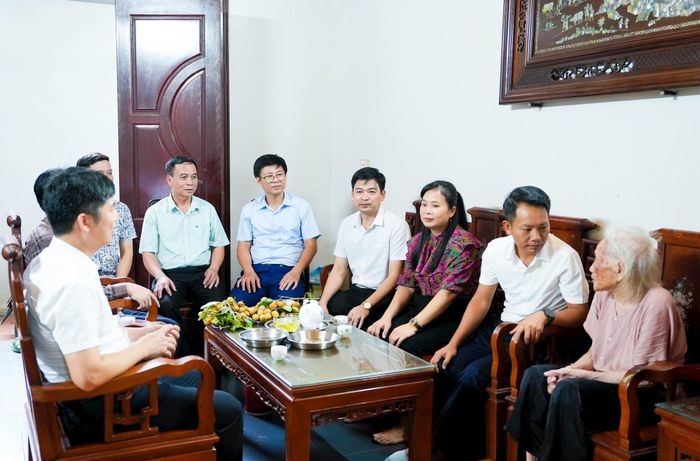 Lãnh đạo xã Quốc Oai ân cần thăm hỏi sức khỏe các lão thành cách mạng. Ảnh: PV