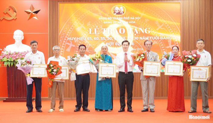 Phó Bí thư Đảng ủy, Chủ tịch UBND xã Dân Hòa Đinh Hữu Bình trao Huy hiệu Đảng tặng các đảng viên. Ảnh: Lê Dung.