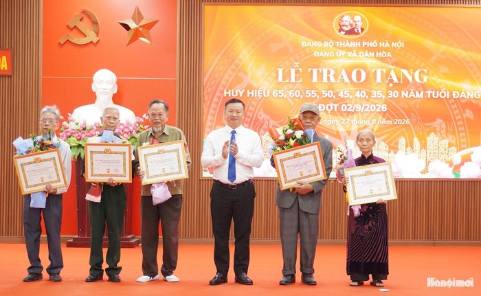 Lãnh đạo xã Dân Hòa trao Huy hiệu Đảng tặng các đảng viên. Ảnh: Lê Dung.