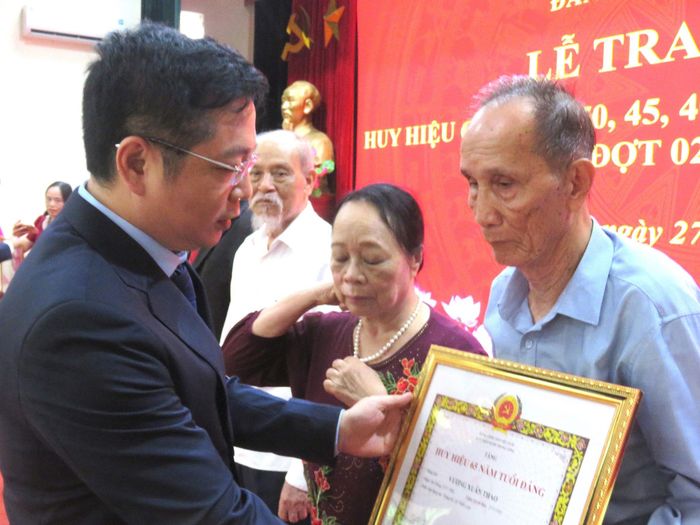 Bí thư Đảng ủy xã Thiên Lộc Phạm Xuân Toàn trao Huy hiệu Đảng tặng các đảng viên. Ảnh: PV