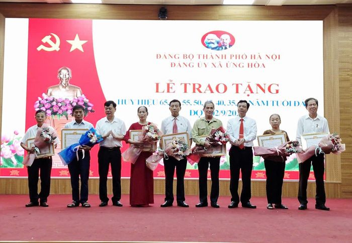 Lãnh đạo xã Ứng Hòa trao Huy hiệu Đảng tặng các đảng viên. Ảnh: Hoàng Sơn