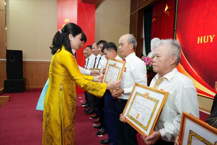 Bí thư Đảng ủy, Chủ tịch HĐND xã Phù Đổng Đặng Thị Huyền trao Huy hiệu tặng các đảng viên. Ảnh: Nguyễn Sơn