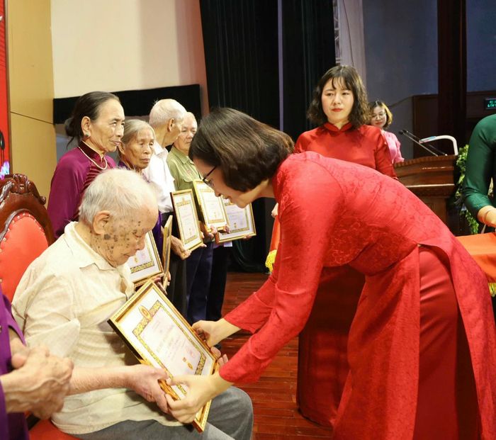 Đồng chí Nguyễn Thị Ngọc Hà - Phó Bí thư Thường trực Đảng uỷ, Chủ tịch HĐND xã Quang Minh trao Huy hiệu Đảng tặng các đảng viên. Ảnh: PV
