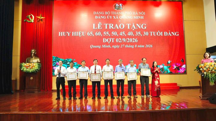 Lãnh đạo xã Quang Minh trao Huy hiệu Đảng tặng các đảng viên. Ảnh: PV