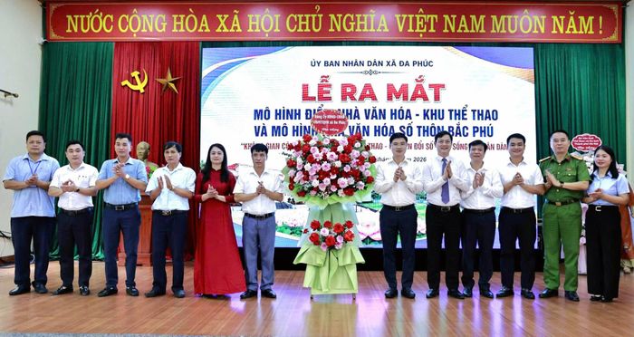 Lãnh đạo xã Đa Phúc tặng hoa chúc mừng thôn Bắc Phú ra mắt mô hình điểm Nhà văn hóa - Khu thể thao và Văn hóa số. Ảnh: Hồng Kỳ